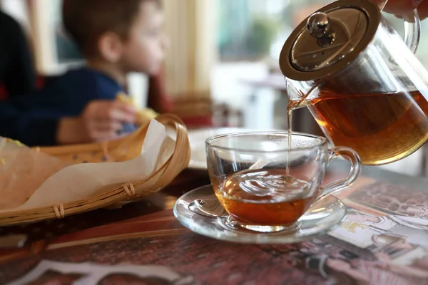 Person pouring herbal tea in a restaurant