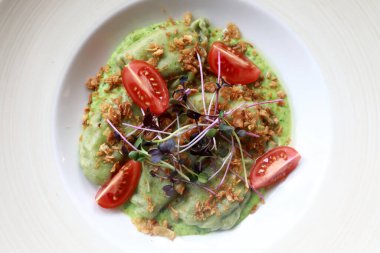 Lokantada beyaz tabakta ıspanaklı börek.