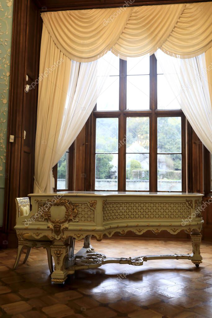View of antique grand piano in mansion
