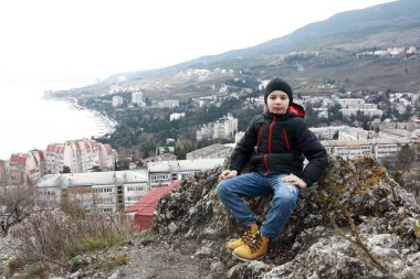 İlkbaharda Bolgatura Dağı 'nda Gurzuf' un arka planındaki çocuk