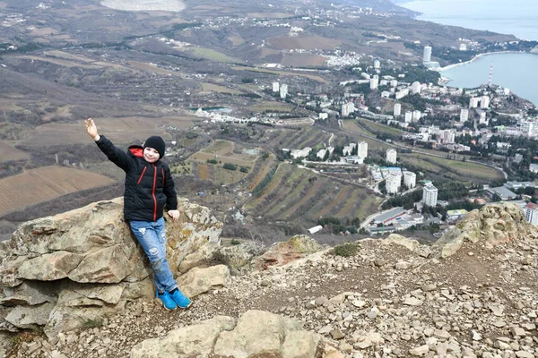 Boy posing on bear mountain in spring, Crimea