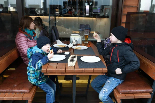 レストランのテラスでピザを食べる二人の兄弟 — ストック写真