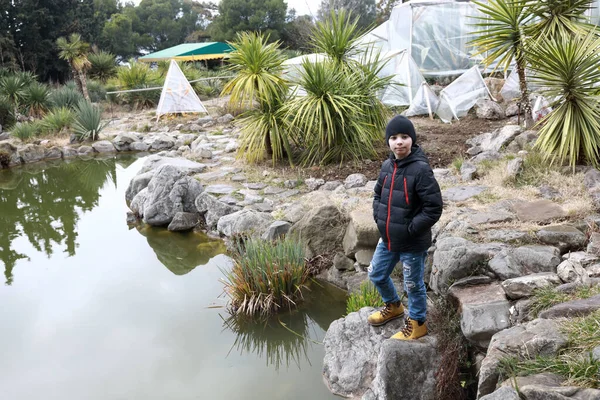 クリミア半島のNikitsky植物園の池のほとりの少年 — ストック写真