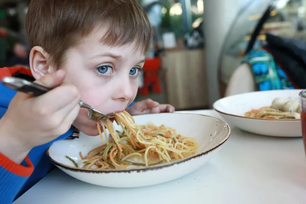 饥饿的孩子在餐馆里吃意大利面 — 图库照片