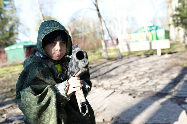 Child playing laser tag in park in spring