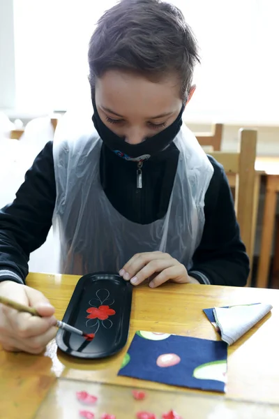 车间桌上戴医用防护面罩的儿童画盘 — 图库照片