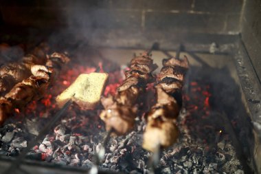 Şöminede mangal kömürü üzerinde ekmek ve domuz boynu pişirmek.
