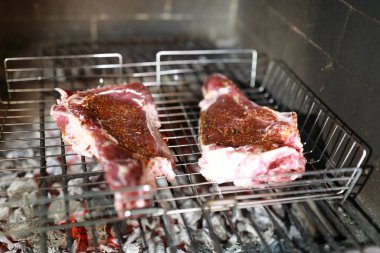 Şöminede kömür üstünde biftek pişirmek.