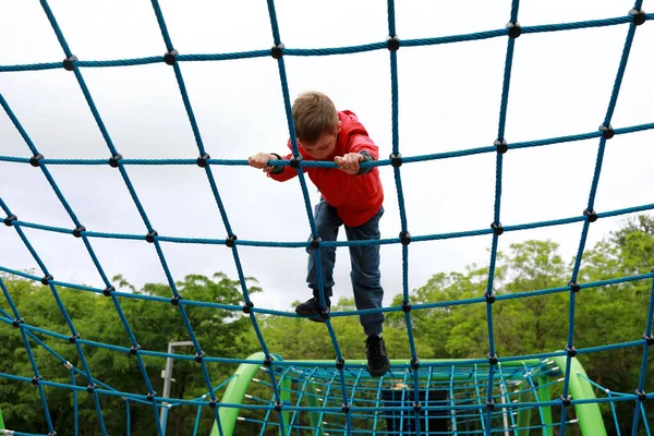 子供は屋外遊び場でネット上で登る — ストック写真