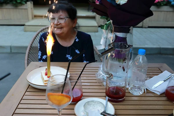 Happy Senior Woman Looking Cake Burning Candle Fireworks Restaurant — Stock fotografie