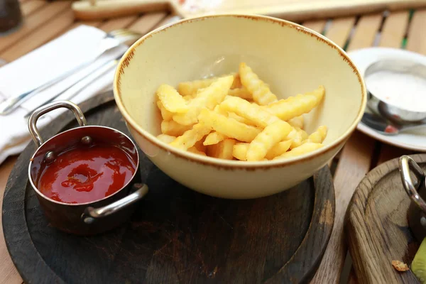 French fries with ketchup on plate in restaurant