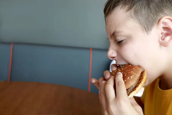 Niño Hambriento Comiendo Hamburguesa Restaurante — Foto de Stock