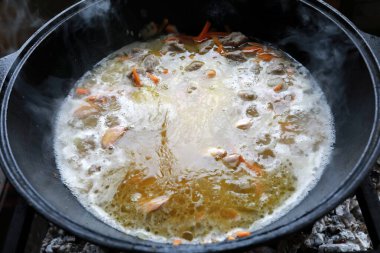 Kazanda pilav hazırlanıyor, çardakta yanıyor.