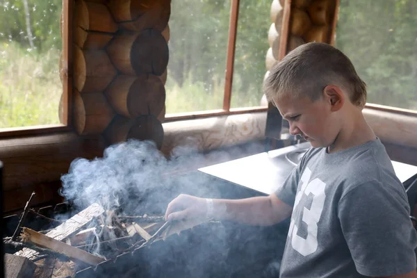 子供はグリルで薪を燃やす ロシア カレリア — ストック写真