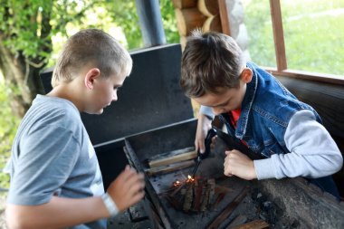Çardakta iki çocuk ızgarada ateş yakıyor, Karelia.