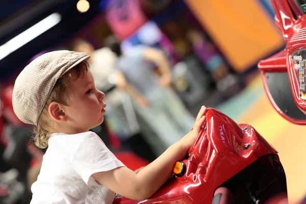 Bambino che gioca macchina simulatore arcade — Foto Stock