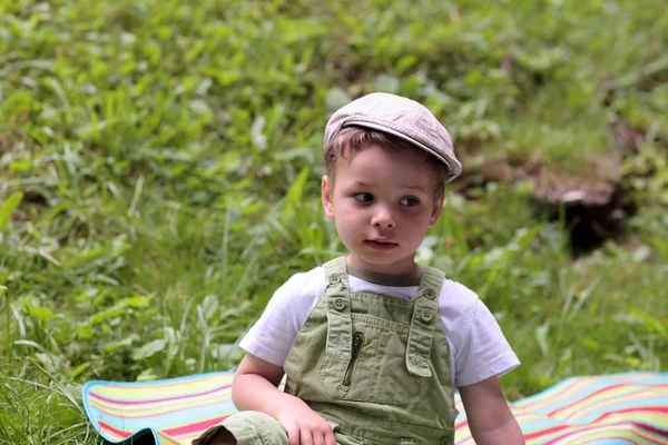 Niño descansando sobre la hierba — Foto de Stock