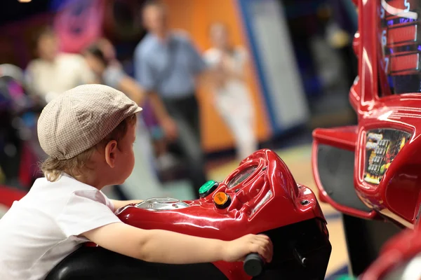 Boy playing arcade simulator machine — Stock Photo, Image