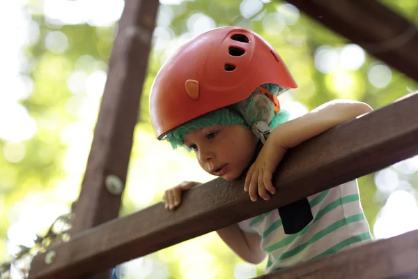 Niño escalador en un puente de madera — Foto de Stock