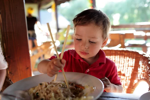 Niño comiendo fideos —  Fotos de Stock