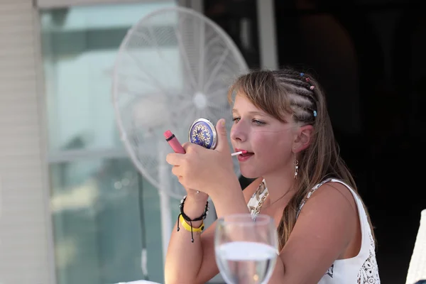 Girl putting lipstick on her lips — Stock Photo, Image