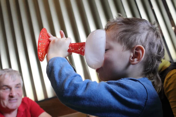 Boy licking a plate of ice cream — Stock Photo, Image