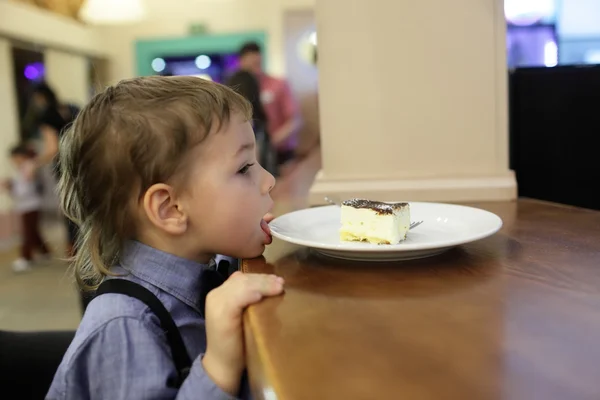 Kind likken plaat met cake — Stockfoto