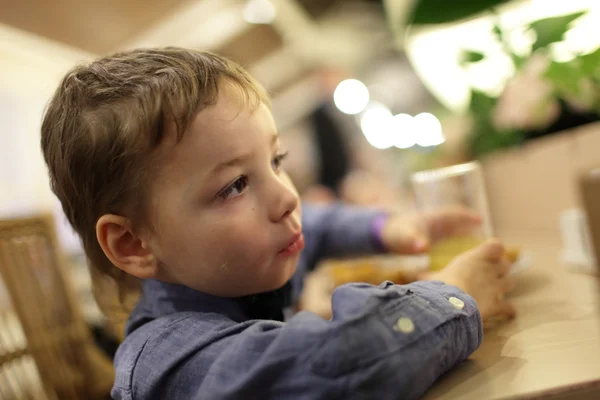 Kid with glass of orange juice — Stock Photo, Image