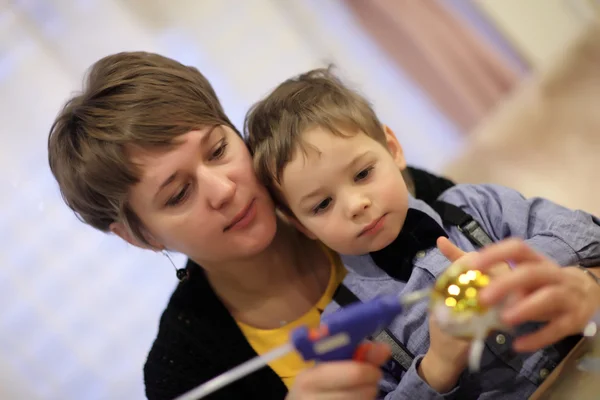 Madre con figlio che decora una palla di Natale — Foto Stock