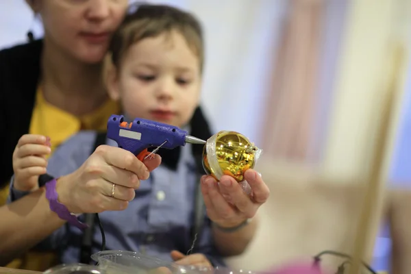 Familie schmückt ein Weihnachtsspielzeug — Stockfoto