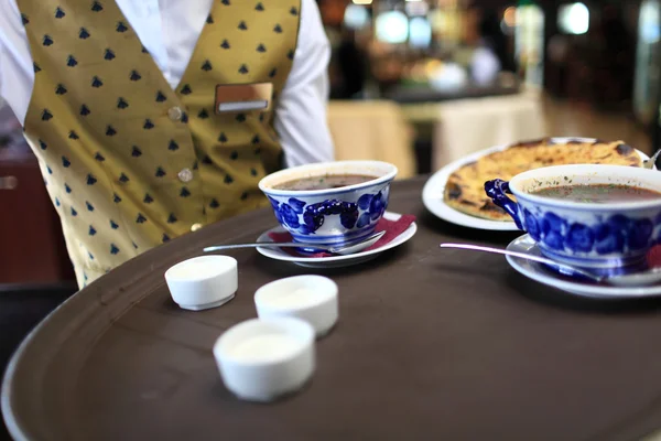 Waiter holding tray with plates of soup — Stock Photo, Image