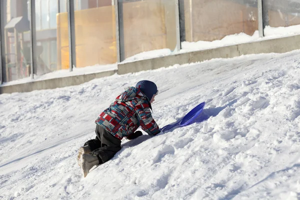 Chłopiec wspinaczka na snowy wzgórza — Zdjęcie stockowe