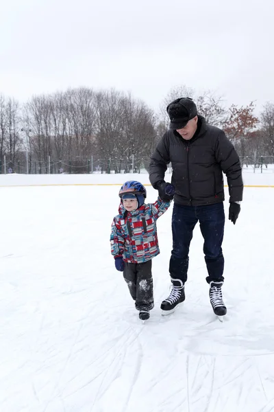 Abuelo con nieto en la pista de patinaje —  Fotos de Stock