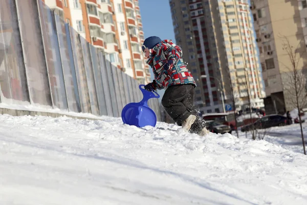 Niño con tabla de esquí escalada en la colina — Foto de Stock