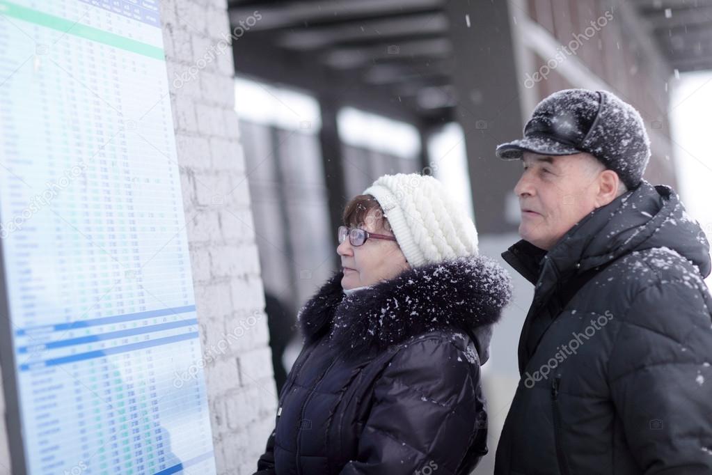 Couple looks at train schedule