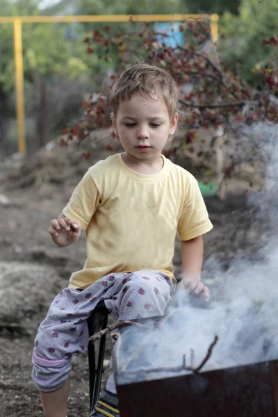 Criança fazendo fogo na grelha — Fotografia de Stock