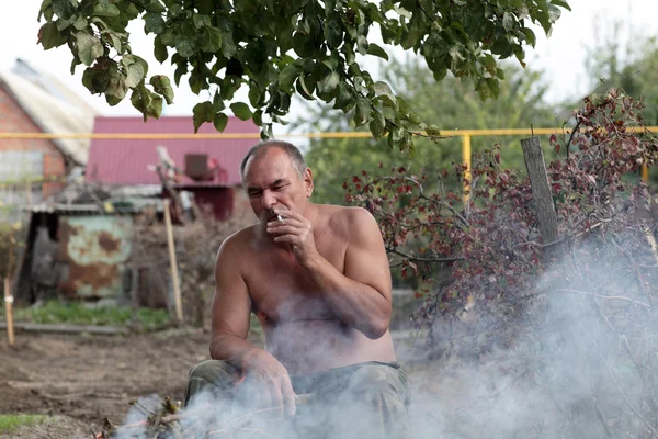 Man smoking at picnic — Stock Photo, Image