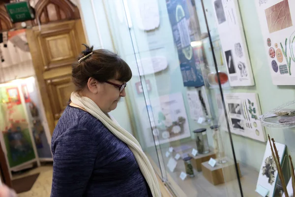 Senior woman looking at exhibit — Stock Photo, Image