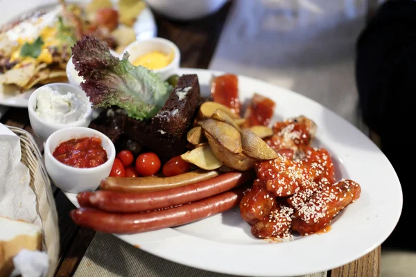 Тарелка с сосисками и овощами — стоковое фото
