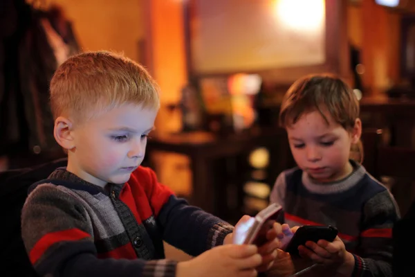 To barn med smarttelefoner – stockfoto