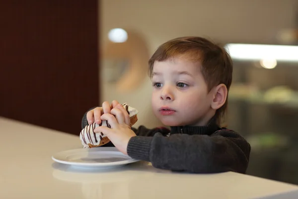 Kid eten éclair — Stockfoto