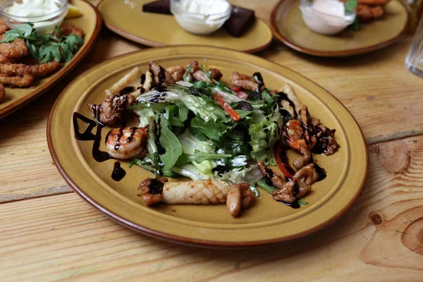 Plate of salad with quid on the table — Stock Photo, Image