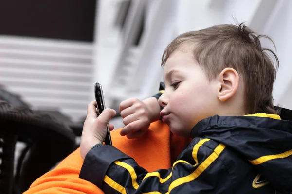 Ребёнок играет со смартфоном — стоковое фото