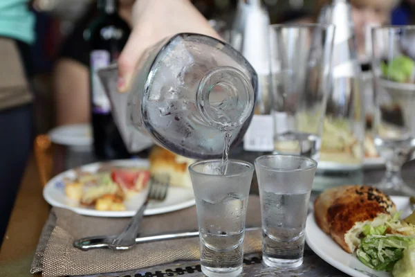 Cameriere versando vodka da caraffa — Foto Stock