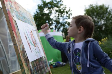 Çocuk boyalar çizer