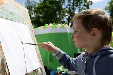 Çocuk boyalar çizer