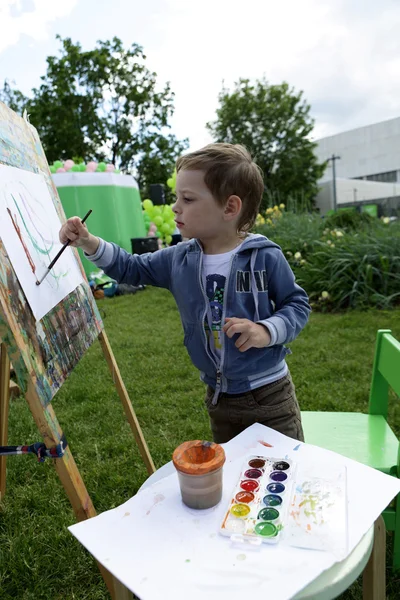 Kid måleri vid staffli — Stockfoto