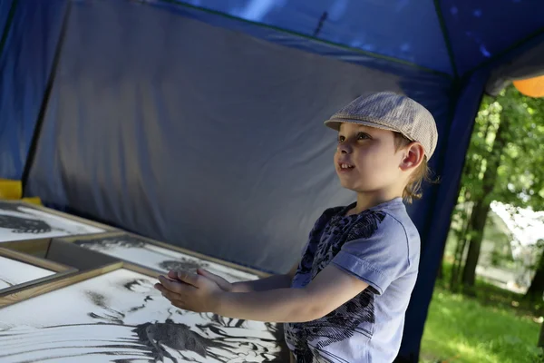 Garçon dessine avec du sable — Photo