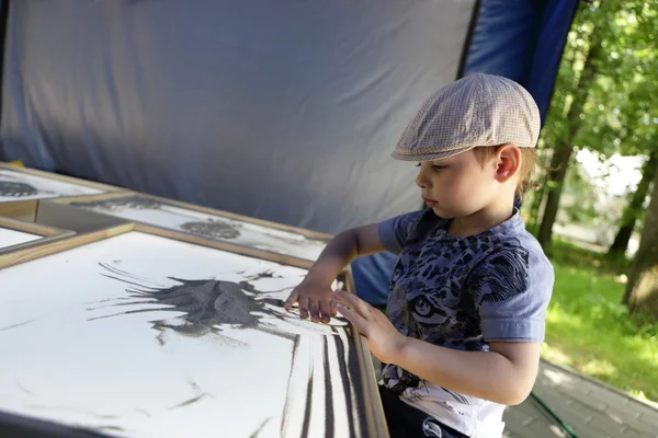 Le gamin dessine avec du sable — Photo