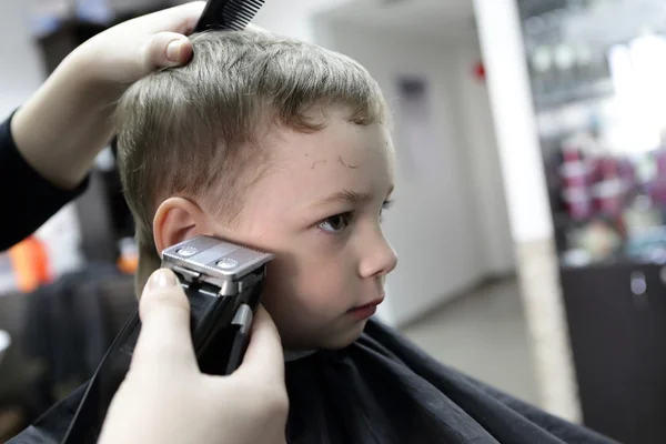 Un niño serio en la peluquería — Foto de Stock